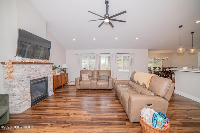 living room featuring a fireplace, vaulted ceiling, wood finished floors, and recessed lighting