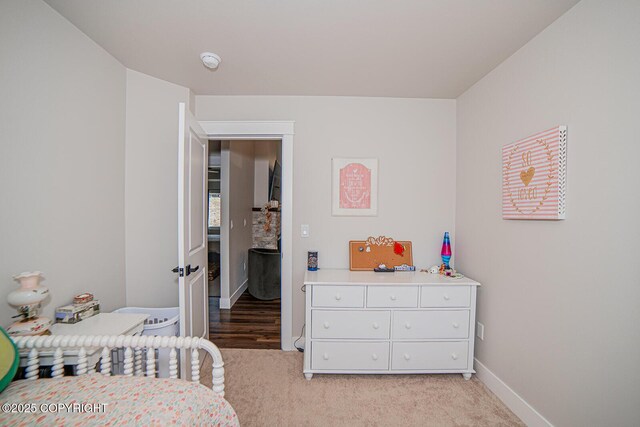 bedroom with light carpet and baseboards