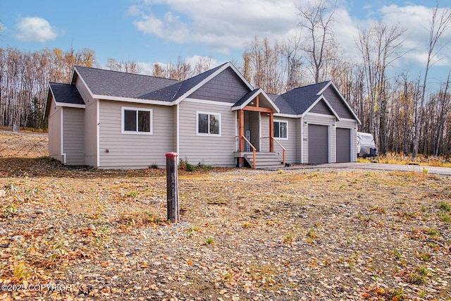 single story home featuring a garage and roof with shingles