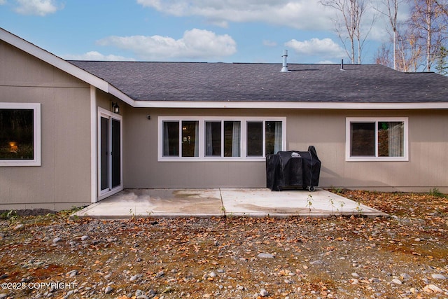 rear view of property with a patio and a shingled roof