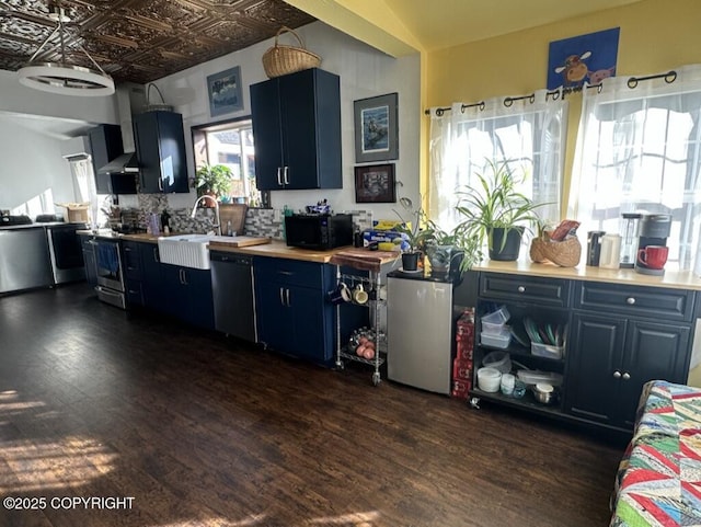 kitchen featuring black appliances, blue cabinetry, dark wood finished floors, and an ornate ceiling