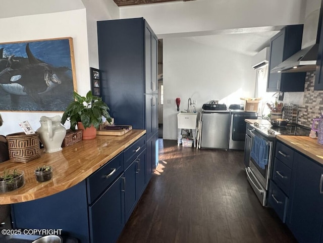 kitchen featuring dark wood finished floors, blue cabinetry, separate washer and dryer, stainless steel range with electric stovetop, and wall chimney exhaust hood