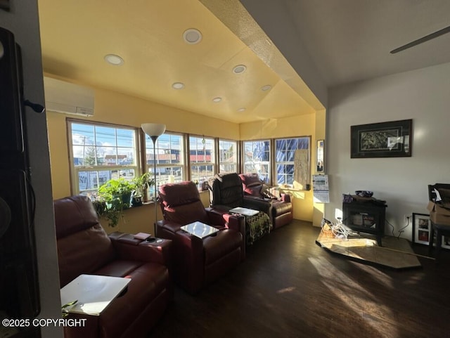 living room featuring an AC wall unit, wood finished floors, a wood stove, and recessed lighting