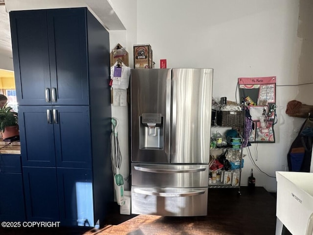 kitchen with blue cabinetry, wood finished floors, and stainless steel fridge with ice dispenser