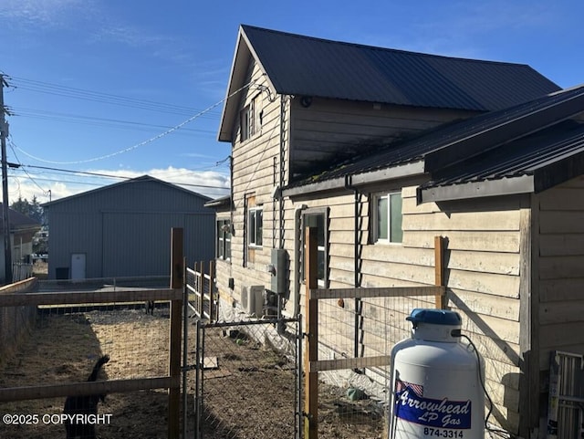 view of property exterior featuring metal roof and an outdoor structure