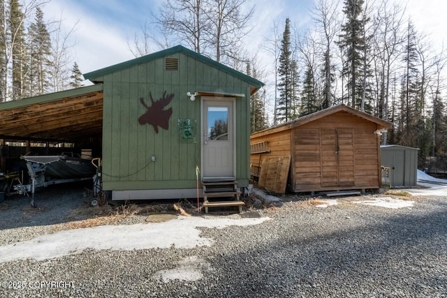 view of shed featuring a carport and entry steps