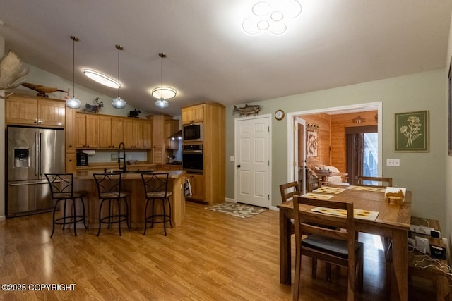 dining space featuring lofted ceiling and light wood-type flooring