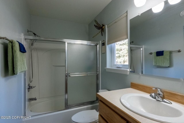 bathroom featuring enclosed tub / shower combo, toilet, and vanity