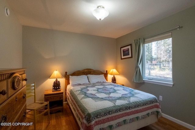 bedroom with wood finished floors and baseboards