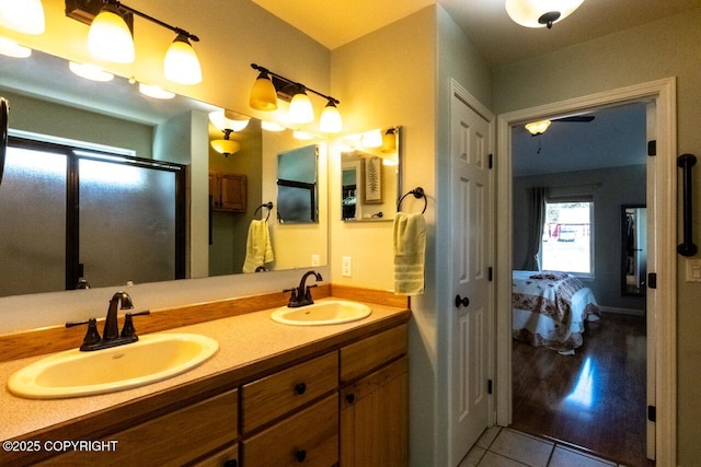 ensuite bathroom with tile patterned flooring, double vanity, ensuite bathroom, and a sink