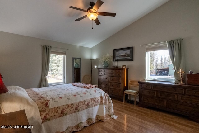 bedroom with ceiling fan, lofted ceiling, and wood finished floors