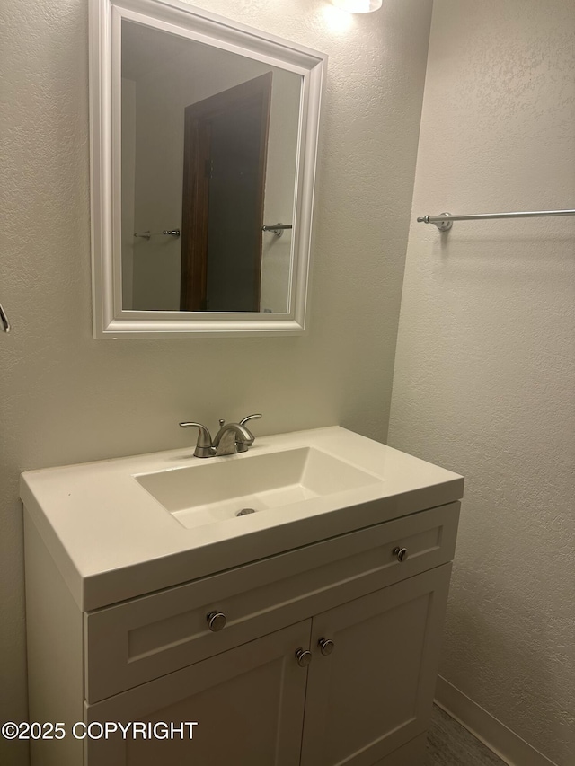 bathroom featuring a textured wall and vanity