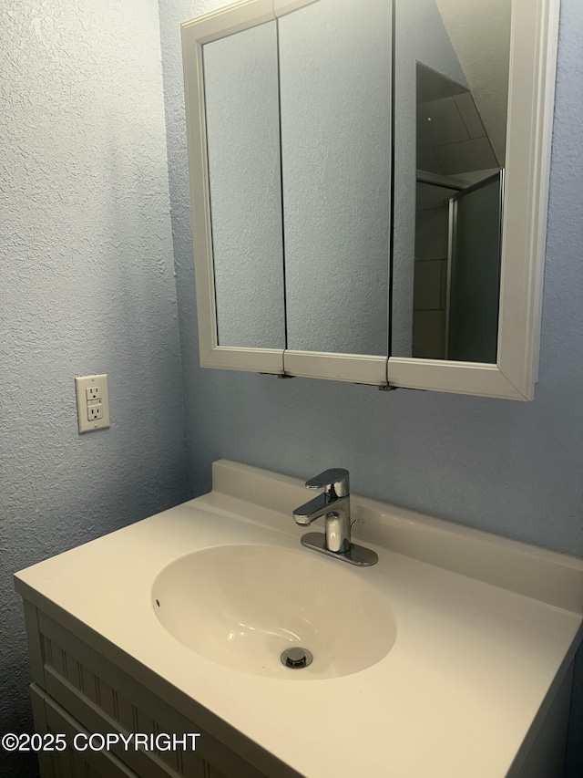 bathroom with a textured wall and vanity