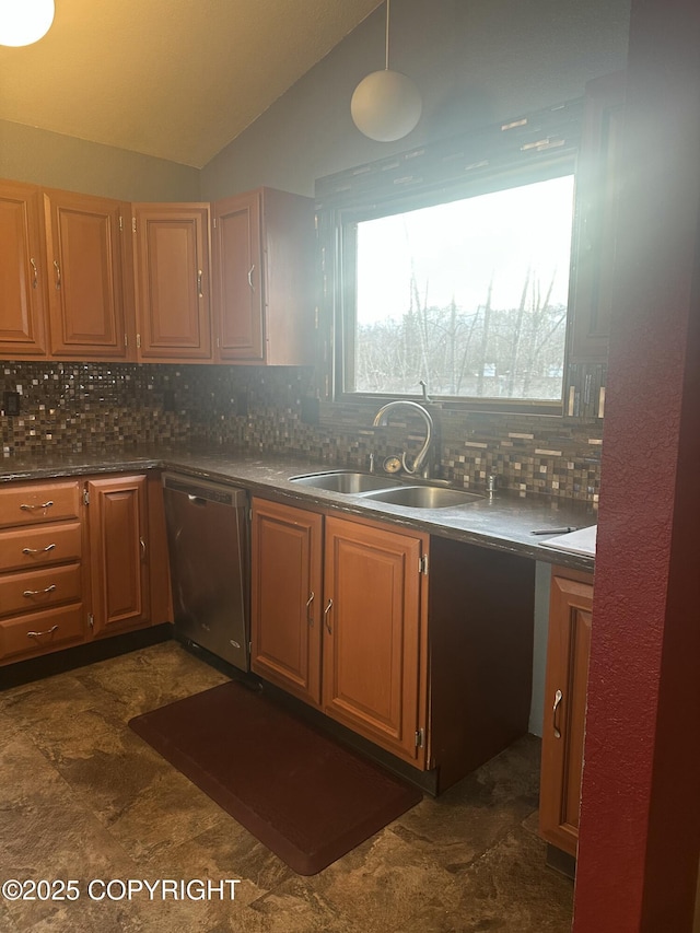 kitchen with dark countertops, backsplash, vaulted ceiling, stainless steel dishwasher, and a sink