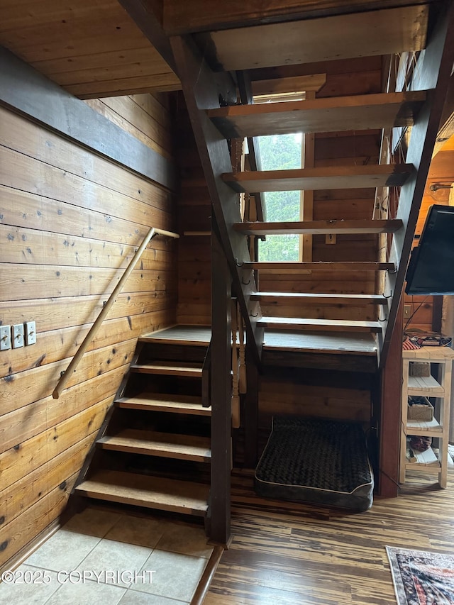 stairway featuring wooden walls and wood finished floors