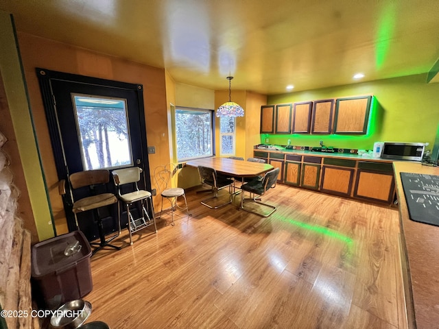 kitchen with light wood-style floors, recessed lighting, pendant lighting, and stainless steel microwave