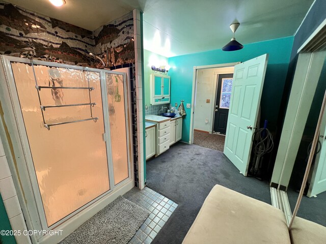 full bathroom featuring a stall shower, vanity, and decorative backsplash