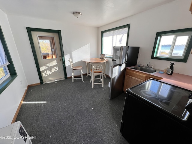 home office with dark carpet, a sink, and baseboards