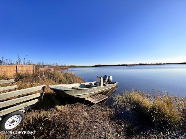 view of dock with a water view and fence