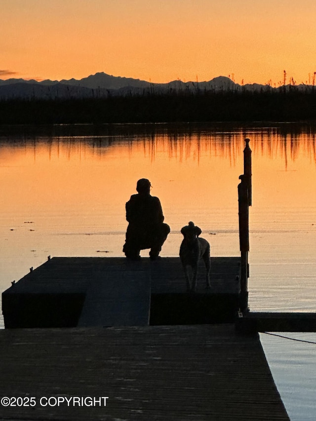 property view of water featuring a boat dock and a mountain view