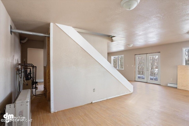 interior space featuring stairway, a baseboard heating unit, and wood finished floors