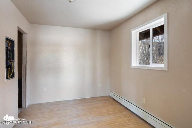 empty room featuring light wood-style flooring and baseboard heating