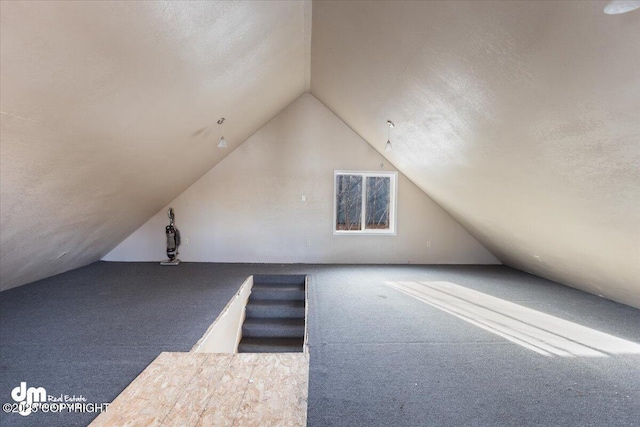 bonus room featuring carpet floors, a textured ceiling, and lofted ceiling