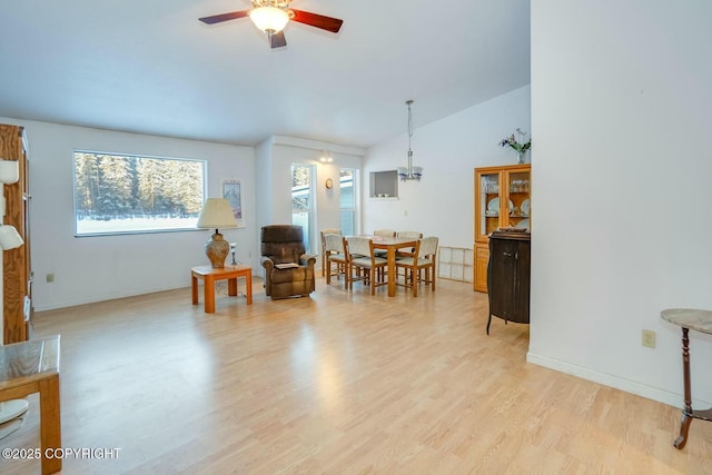 dining area with lofted ceiling, ceiling fan, light wood finished floors, and baseboards