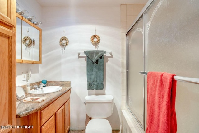 full bath featuring toilet, vanity, and a shower with door