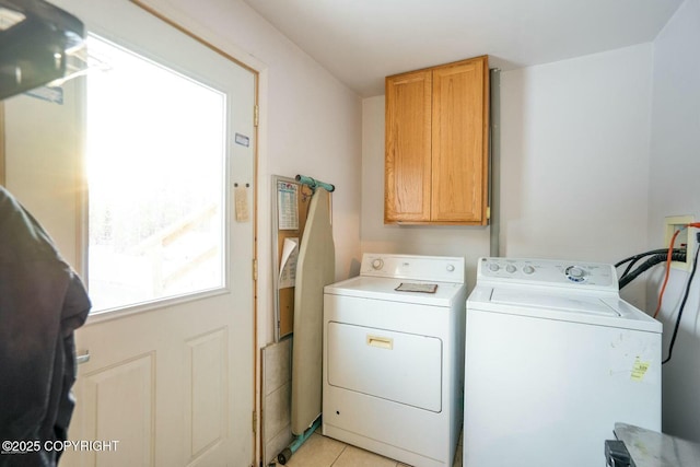 laundry area with cabinet space, washer and clothes dryer, and light tile patterned flooring