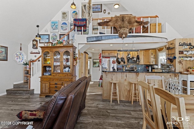 dining area featuring dark wood finished floors, high vaulted ceiling, stairs, and baseboards