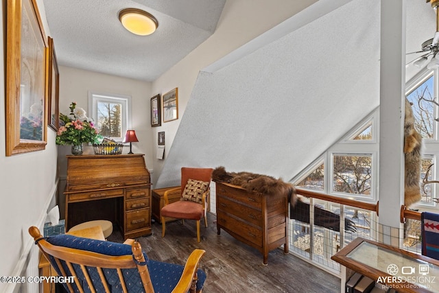 sitting room featuring ceiling fan, lofted ceiling, a textured ceiling, and wood finished floors