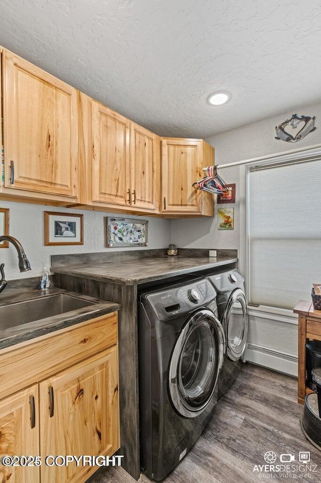 laundry room featuring cabinet space, dark wood-style flooring, a sink, a textured ceiling, and washing machine and dryer