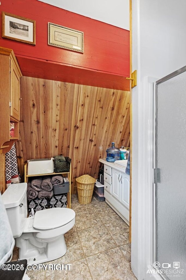 full bathroom with wooden walls, a shower stall, and toilet