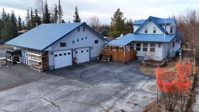 view of front facade featuring a garage, driveway, and metal roof