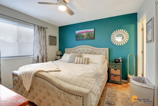 bedroom with an accent wall and a ceiling fan