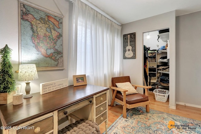 office area with light wood-style floors and baseboards