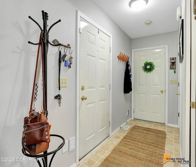 entryway featuring baseboards and light tile patterned flooring