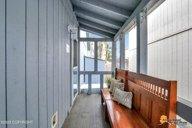 sunroom featuring vaulted ceiling with beams