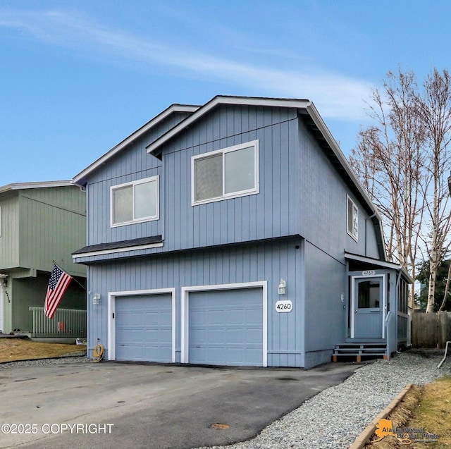 view of front facade with aphalt driveway, entry steps, and an attached garage