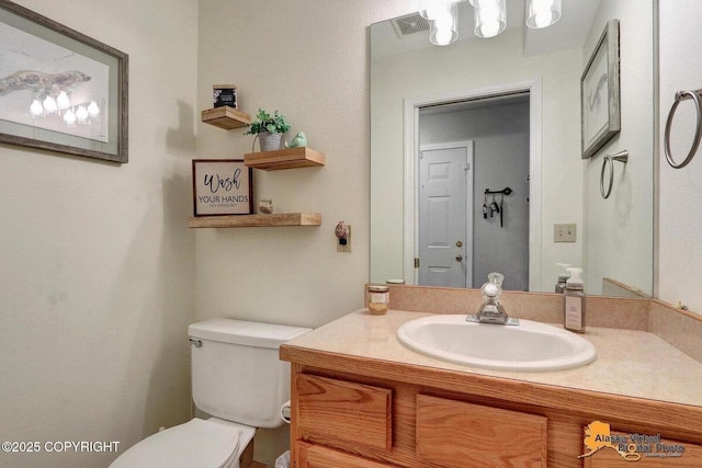 bathroom with visible vents, vanity, and toilet