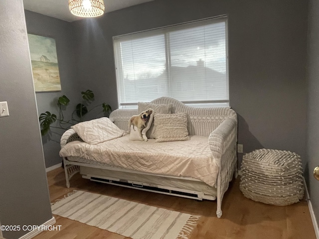 bedroom with baseboards and wood finished floors