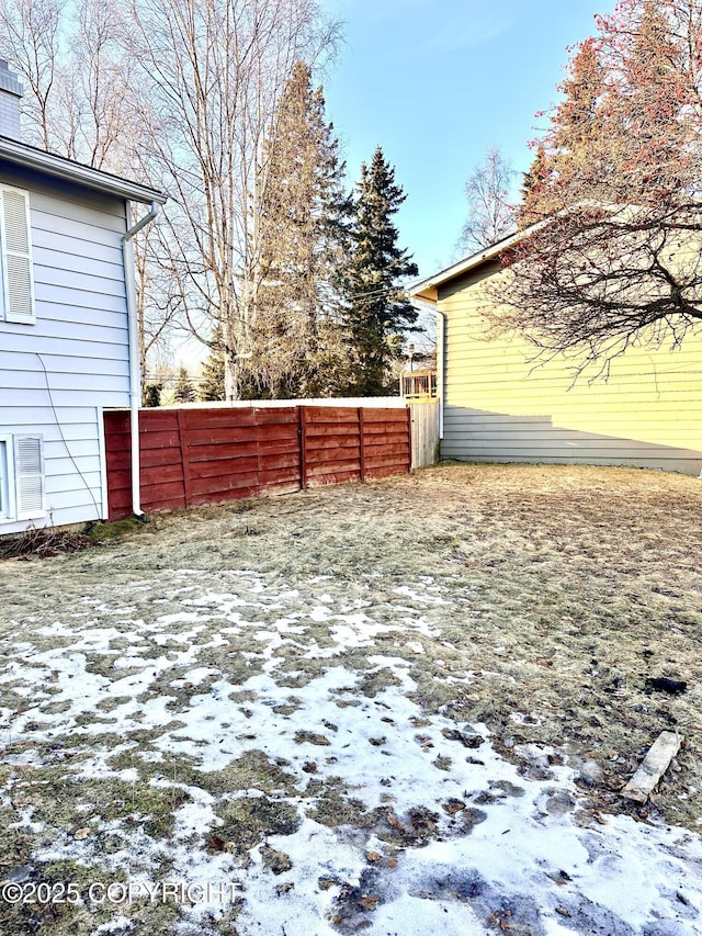 yard covered in snow with fence