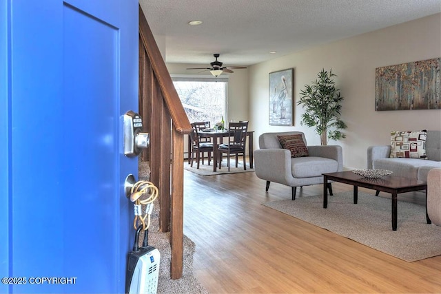 entrance foyer featuring a textured ceiling, light wood finished floors, and a ceiling fan