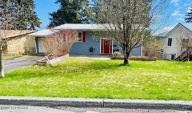 ranch-style home with driveway and a front yard