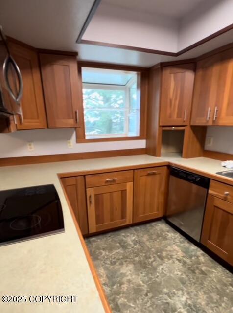 kitchen with dishwasher, brown cabinets, black electric stovetop, light countertops, and a sink