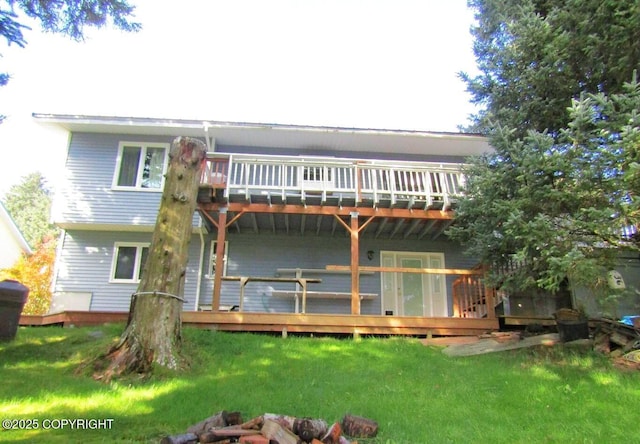 rear view of property featuring a lawn and a wooden deck