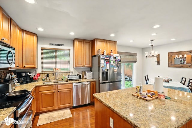 7210 Akutan Cir, Anchorage, AK 99504 - kitchen with a sink, stainless steel appliances, light wood finished floors, a chandelier, and light stone countertops