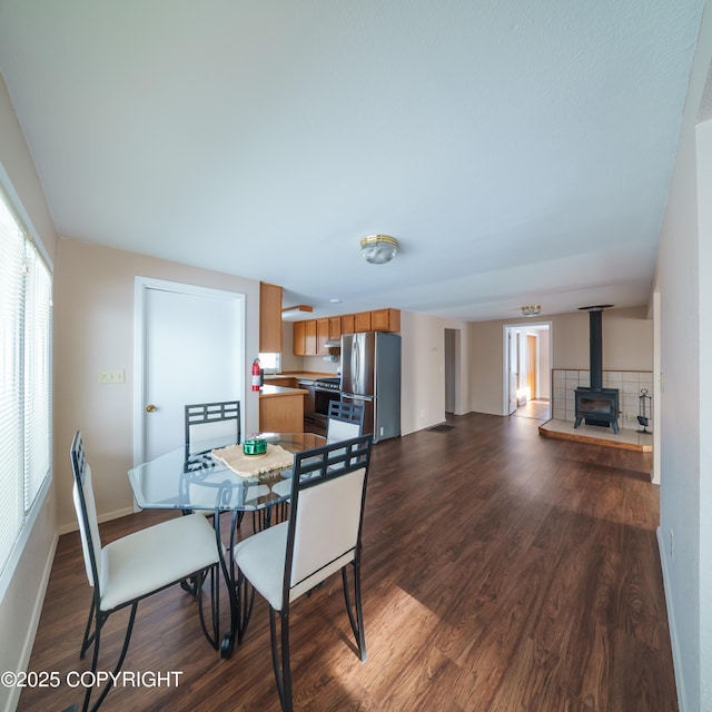 221 Creekside St, Anchorage, AK 99504 - dining space featuring a wood stove, dark wood-type flooring, and baseboards