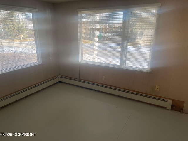 empty room with wood walls and a baseboard radiator